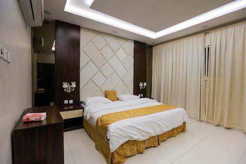 a bedroom with a large bed and a desk in it at شقق مساكن الاطلال الفندقيه in Riyadh
