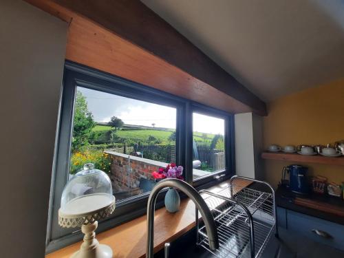 a kitchen with a large window with a sink and a sink at Longstone Luxury Country Boutique Two Bedroom Cottage, Exmoor, Challacombe, North Devon in Challacombe