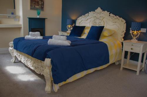 a blue and white bed with blue sheets and pillows at Rose & Crown Rooms in Beverley