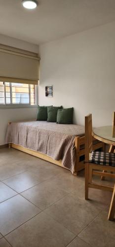 a bedroom with a bed and a table in it at AIRES DEL CERRO 6 CON COCHERA in Salta