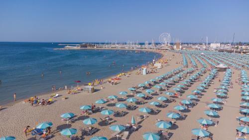 a beach with a lot of chairs and umbrellas at Apartment 4 people in Rimini 400m from the beach in Rimini
