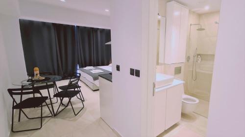 a white bathroom with a table and chairs and a bathroom at STAY Mezarina Apt 2 in Ayia Napa