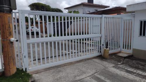 a white gate in front of a house at Casa bela in Lauro de Freitas
