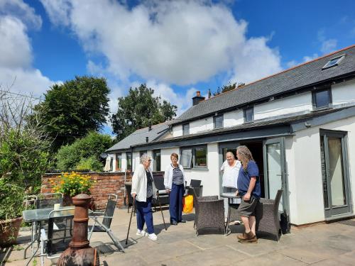 a group of people standing outside of a house at Longstone Luxury Country Boutique Two Bedroom Cottage, Exmoor, Challacombe, North Devon in Challacombe