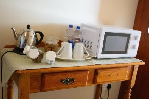 a microwave sitting on top of a wooden table at De Oude Yotclub in Oudtshoorn