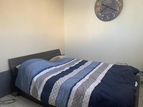 Tiercé的住宿－Maison au calme，卧室配有一张床,墙上挂着一个钟