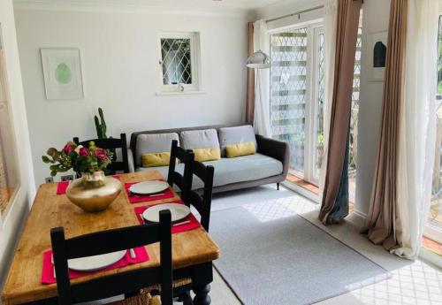 a living room with a table and a couch at Oak Lodge in Stapleford Tawney