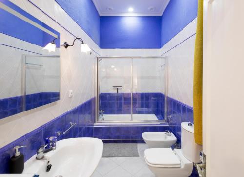 a blue and white bathroom with a toilet and a sink at PALACIO DON CARLOS in Jerez de la Frontera
