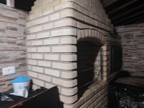 a brick wall with a brick oven in a room at Aconchego in Mairinque