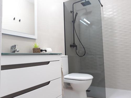 een badkamer met een douche, een toilet en een wastafel bij Bungalow con Patio y Terraza Solárium in Torrevieja