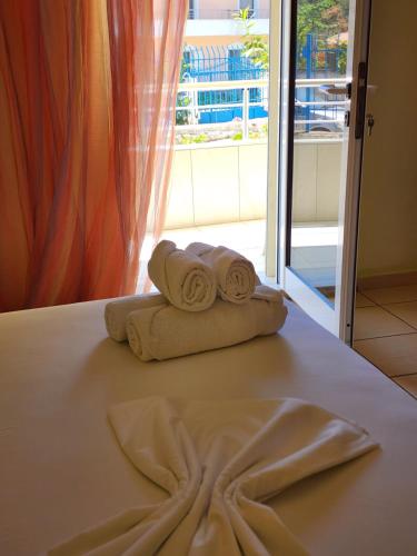 two towels sitting on top of a bed in a room at Amelia Apartments in Ksamil