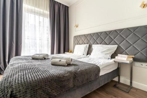 una camera da letto con un grande letto con due cuscini sopra di Mennica Residence by Golden Apartments a Varsavia