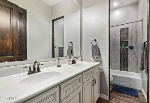 a white bathroom with a sink and a shower at Phoenix Home with heated pool, desert views & hot tub in Anthem