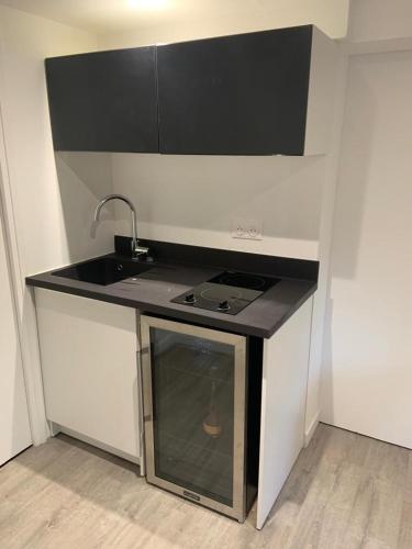 une petite cuisine avec un évier et une cuisinière dans l'établissement *Romance Jacuzzi* Appartement Spa pour les amoureux ou les solos, à Deuil-la-Barre