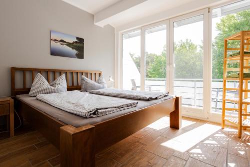 オストゼーバート・ディアーハーゲンにあるDER STÖRTEBEKER - "Apartment Wustrow" Apartments hinter den Dünenの大きな窓付きの客室のベッド1台分です。