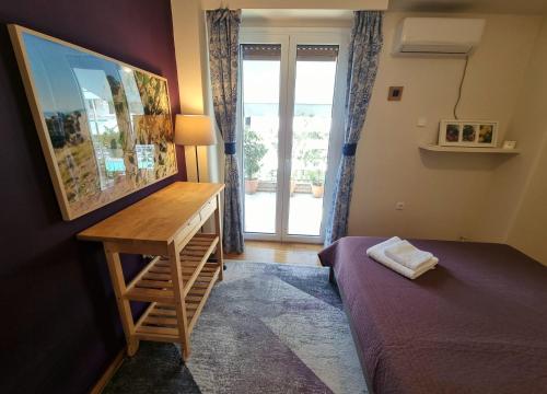 a bedroom with a desk and a bed and a window at Cozy Apartment With Wrap Around Balcony in Athens