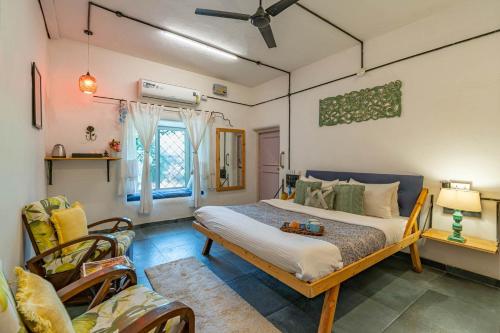 1 dormitorio con 1 cama grande y 1 sofá en StayVista's Suman Vatika - Pench - Outdoor Pool, Jacuzzi, Rainshower & Terrace, en Khawāsa