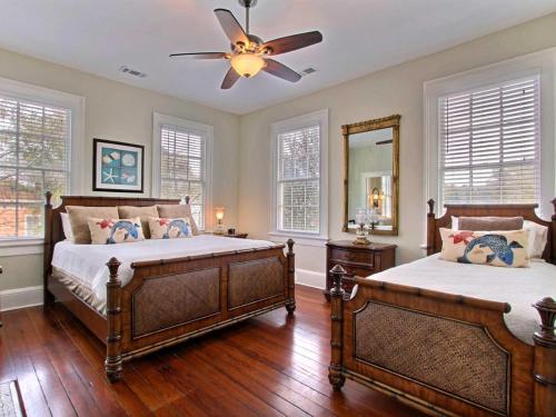 een slaapkamer met 2 bedden en een plafondventilator bij Forsyth Park West Mansion in Savannah