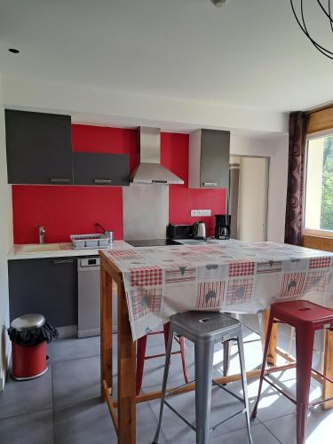 a kitchen with a table and some chairs in it at Hôtel Les Mouflons in Le Mont-Dore