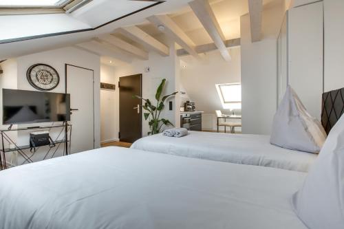 two beds in a room with a tv and a bedroom at George Apartment in Düsseldorf