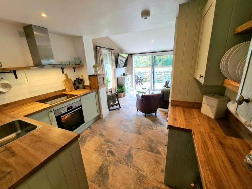 a kitchen with green cabinets and a large window at Ingleside Cottage in Glaisdale