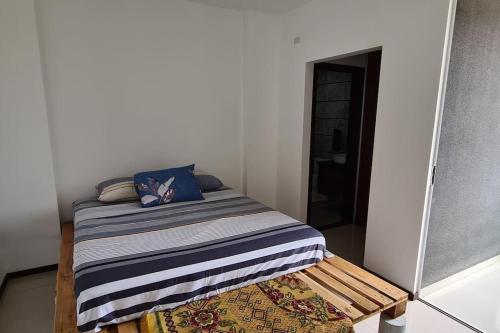 a small bedroom with a bed with a blue pillow at Condominio Atlas in Santa Cruz de la Sierra