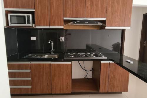 eine Küche mit einer Spüle und einer Mikrowelle in der Unterkunft Condominio Atlas in Santa Cruz de la Sierra
