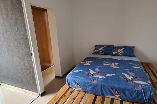 Un dormitorio con una cama con una manta azul con pájaros. en Condominio Atlas, en Santa Cruz de la Sierra