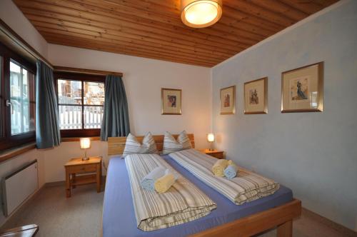 a bedroom with a blue bed with two pillows at Chasa Sager 2 in Scuol