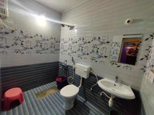La salle de bains est pourvue de toilettes et d'un lavabo. dans l'établissement Jawa Homestay, à Madikeri
