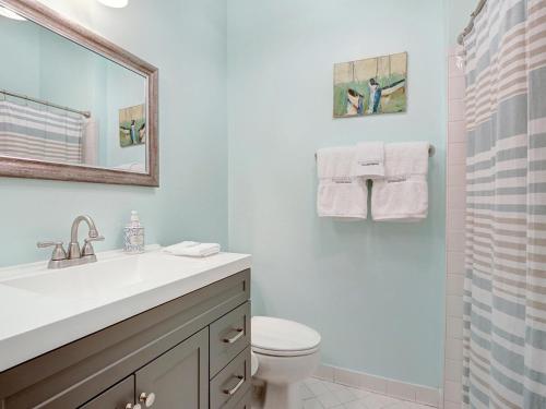 ein Badezimmer mit einem Waschbecken, einem WC und einem Spiegel in der Unterkunft Hideaway on Jones in Savannah