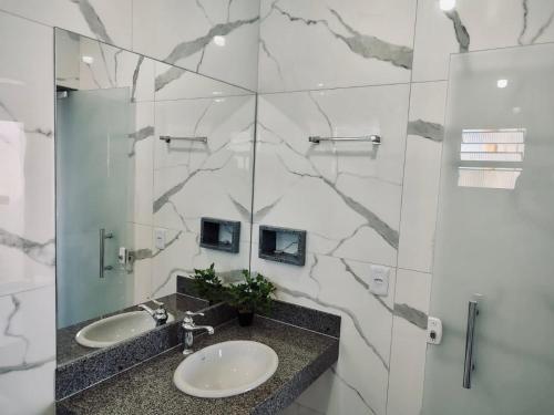 uma casa de banho com 2 lavatórios e um espelho em CHALÉS GUARAÍPE em Guarapari
