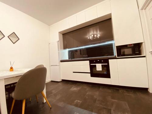 a kitchen with a dining table and a microwave at DeLight Apartments in Boryspilʼ