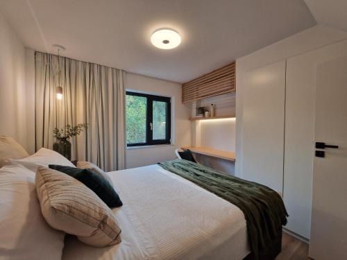 Schlafzimmer mit einem großen weißen Bett und einem Fenster in der Unterkunft Loft Studios in Artemida