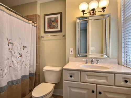 bagno con lavandino, servizi igienici e specchio di Forsyth Park West Garden Level a Savannah