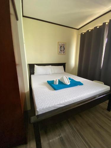 Una cama con una bandeja azul encima. en Pantawan Guest House en Tagbilaran City
