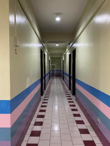 Pantawan Guest House في تاغبيلاران سيتي: ممر فارغ في مبنى عليه خطوط ملونة على الجدران