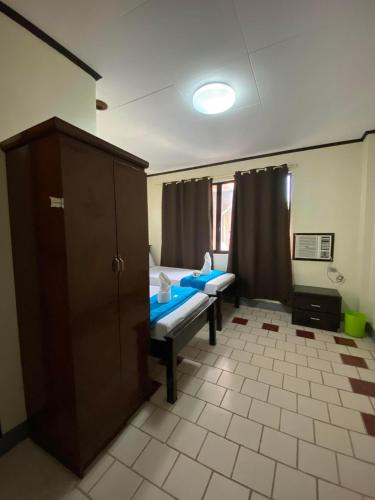 Cette chambre comprend 2 lits et une armoire. dans l'établissement Pantawan Guest House, à Tagbilaran