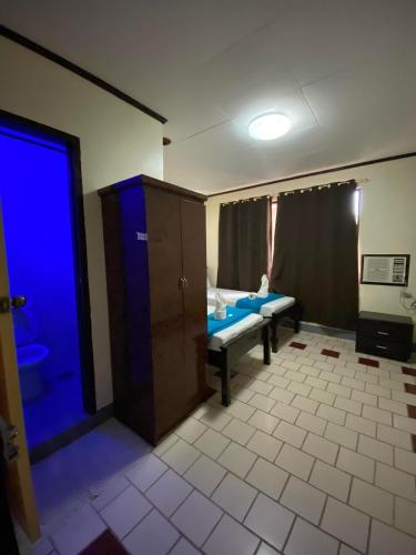 Pantawan Guest House في تاغبيلاران سيتي: غرفه بباب ازرق وغرفه بسرير