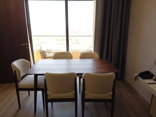 a dining room table with chairs and a large window at H Luxury Hotel in Wadi Musa