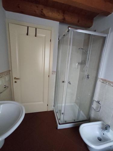 een badkamer met een glazen douche en een wastafel bij Appartamento Cristol in Gargnano