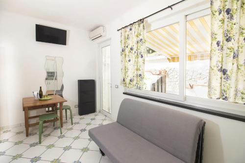 sala de estar con sofá y ventana en La Turrita Apartments en Ischia