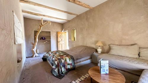 a small bedroom with a bed and a table at Alliance Berbère - Vallée d'Aït Bouguemez in Timit