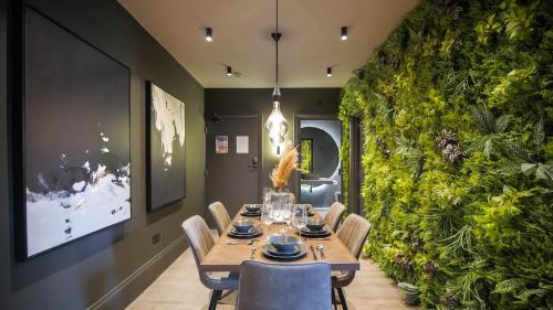 a dining room with a table and chairs and a green wall at Midnight by The Heim Residences in Manchester
