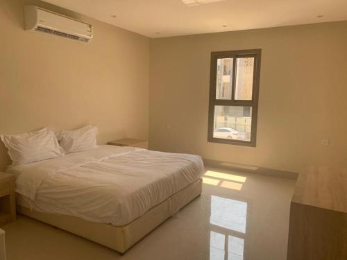 a bedroom with a white bed and a window at Mayyon Airport 101 in Riyadh