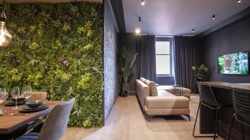 a room with a green wall with a table and chairs at Midnight by The Heim Residences in Manchester