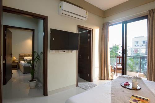 a hotel room with a bed and a large window at BedChambers Serviced Apartment, Medicity in Gurgaon