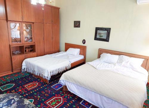 a bedroom with two beds and a rug at Liora's Place in Korçë
