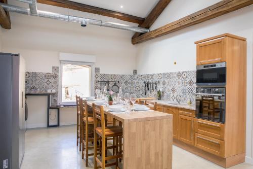 une cuisine avec une grande table et des chaises en bois dans l'établissement Le domaine du pilat, à Saint-Étienne