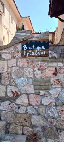 a sign on the side of a stone wall at Boutique Eptalofos 15min from airoport and sea in Kouvarás